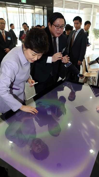 2013년 12월 박근혜 대통령이 한국과학기술원을 방문해 아이카이스트 김성진 대표로부터 터치테이블에 대한 설명을 듣고 있다. 이 자리에서 박 대통령은 “​창조 교육을 하면 집중력도 높아지고 수업이 더욱 재미있을 것”​이라고 말했다. 사진=연합뉴스