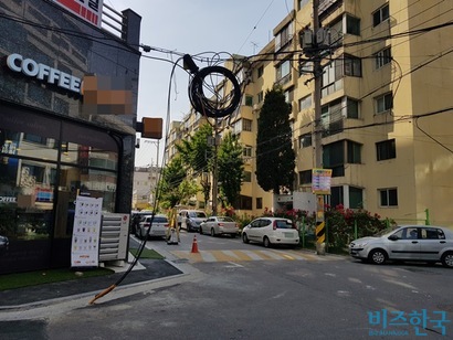 서울시 은평구 연서로17길의 한 사거리 골목. LG유플러스와 CJ헬로비전의 광케이블선이 허공에서 내려와 도로에 매립돼 있어 주민들이 불안에 떨어야만 했다.  사진=유시혁 기자