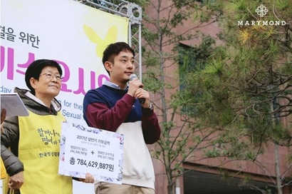 윤홍준 대표가 위안부 피해자 사과를 요구하는 수요집회에 참가해 수익금을 전달하고 있다. 사진=마리몬드 제공