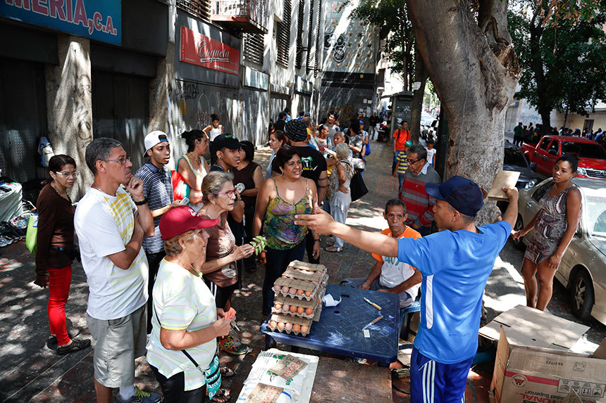 올 3월 10일, 베네수엘라의 식료품 노점상이 정전으로 인해 직불카드로 결제할 수 없다고 말하고 있다. 직불카드는 인플레이션 때문에 가장 널리 쓰이는 결제 수단이다. 사진=AP/연합뉴스