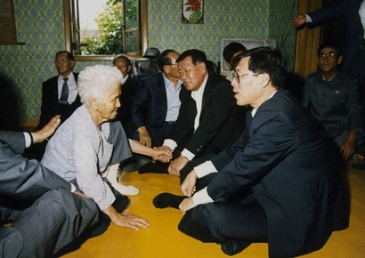 정주영 명예회장이 1998년 6월 북한에 있는 강원도 통천군 노상리에 방문해 친척들과 담소를 나눴다.  사진=연합뉴스