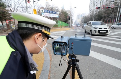 대전 둔산경찰서 관계자가 11일 오후 대전시 서구 둔산동 한 초등학교 앞 어린이보호구역(스쿨존)에서 과속 차량을 단속하고 있다. 국회는 10일 스쿨존에 과속단속 카메라 설치를 의무화하고, 스쿨존 내 사망사고 가해자를 가중처벌하는 것을 골자로 하는 ‘민식이법’을 상정·처리했다. 사진=연합뉴스