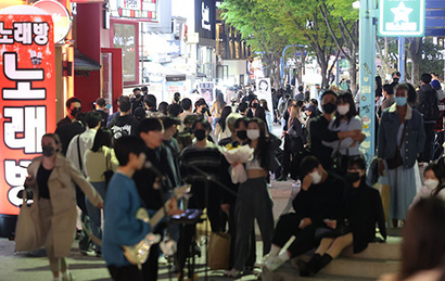 코로나19 사회적 거리두기 해제를 하루 앞둔 17일 오후 서울 마포구 홍대입구역 인근에서 시민들이 버스킹 공연을 관람하고 있다. 사진=연합뉴스
