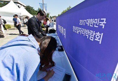 아무 경력 없이 노동시장에 자신을 팔아야 하는 구직자들은 기업을 설득하기 위해 여러 수단을 동원하는 데, 이 역시 본질은 ‘좋은 간판을 다는 것’이라 할 수 있다. 서울 여의도 국회 잔디마당에서 열린 ‘2017 대한민국 청년일자리박람회’에 참석한 취업준비생들이 이력서를 작성하고 있다. 사진=비즈한국DB