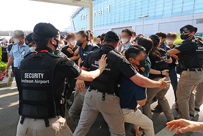 6월 22일 인천국제공항 제1여객터미널에서 직원들이 보안검색 노동자 정규직화 관련 브리핑을 위해 브리핑룸으로 이동하는 구본환 인천국제공항공사 사장을 향해 항의하고 있다. 사진=연합뉴스