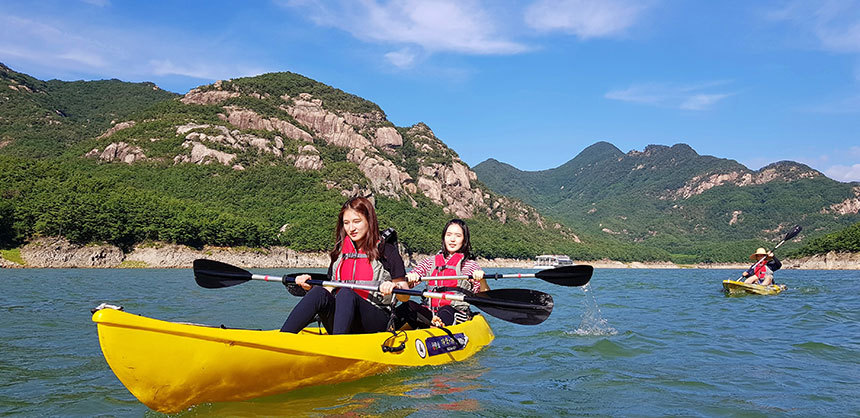 청풍호 카누카약체험장. 잔잔한 호수라 물결이 거의 없어서 노를 젓는 게 별로 힘들지 않다. 뒤로 비단에 수를 놓은 듯 아름답다는 금수산이 펼쳐진다. 사진=청풍호 카누카약체험장 제공