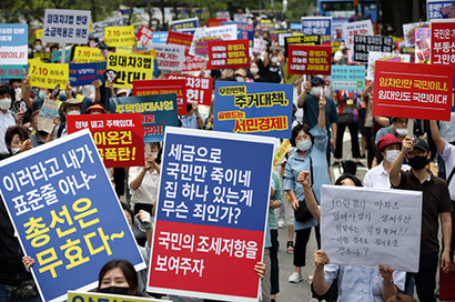 7월 25일 오후 서울 중구 예금보험공사 앞에서 열린 ‘소급적용 남발하는 부동산 규제 정책 반대, 전국민 조세 저항운동 촛불집회’ 참가자들이 구호를 외치고 있다. 사진=연합뉴스