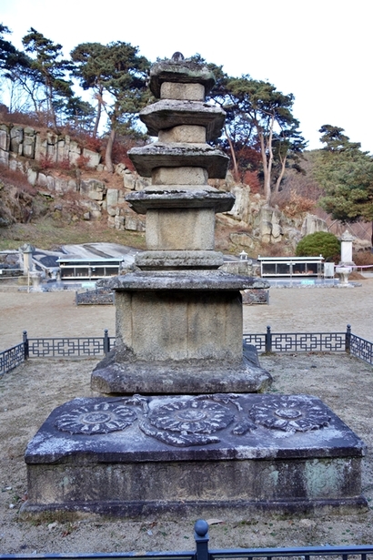 삼층석탑 아래에는 연꽃무늬 조각 선명한 배례석이 누워 있다. 이 배례석의 용도는 확실치 않으나 그 위에 음식을 차리거나 향을 피웠을 것으로 생각된다. 이렇게 불상과 석등, 석탑, 배례석 등이 한 줄로 나란히 서 있는 것도 관촉사만의 특징이다. 사진=구완회 제공