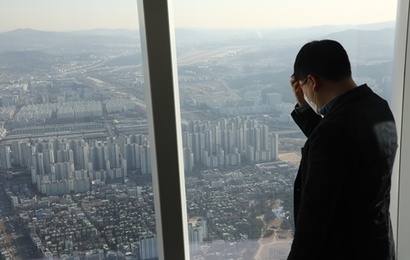 지난 6일 서울 송파구 신천동 롯데월드타워 전망대 ‘서울스카이’​에서 한 청년이 강남 일대 아파트를 내려다보고 있다. 사진=박정훈 기자