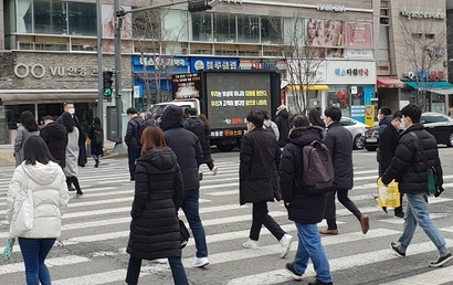 클로저스 시위 트럭 앞의 횡단보도를 건너는 시민들. 큼지막한 문구가 눈에 띄어 시민들의 이목을 끌기 쉽다. 사진=예스미디어 제공