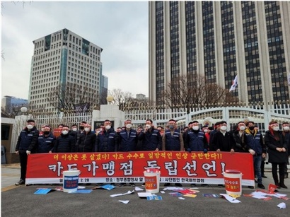 정부가 적격비용 산정으로 카드 수수료율에 개입하고 있지만 가맹점과 카드사의 갈등은 계속된다. 한국마트협회 소속 점주들과 관계자들이 ​지난 2월 28일 ​서울 종로구 정부서울청사 앞에서 기자회견을 열고 일반가맹점 카드수수료 인상 철회를 촉구하고 있다. 사진=한국마트협회