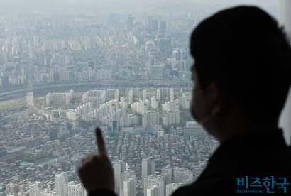 서울 송파구 롯데월드타워 전망대에서 한 시민이 서울 아파트 단지를 내려다 보는 모습. 사진=박정훈 기자