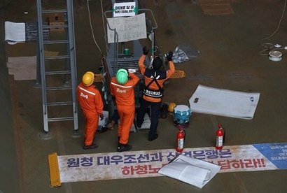 대우조선해양 하청 노사협상이 극적으로 타결된 22일 오후 대우조선 소방대원이 1독에서 점검 농성 중인 유최안 금속노조 거제통영고성 조선하청지회 부지회장을 살펴보고 있다. 점거가 풀린 이후 대우조선해양은 빠르게 작업을 재개했다. 사진=연합뉴스