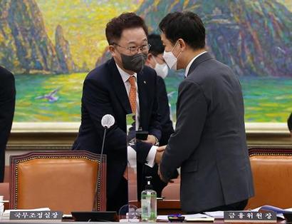 산업은행 본점 부산 이전을 추진하는 강석훈 산업은행 회장에 대한 내부 불만이 상당하다. 지난 8월 22일 강석훈 산업은행 회장(왼쪽)이 국회에서 열린 정무위원회 전체회의에서 김주현 금융위원장과 인사하고 있다. 사진=국회사진취재단