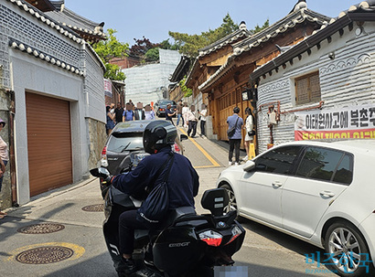 15일 오후 2시 10분경 폭 10m 남짓한 좁은 골목길에 오토바이, 승용차, 관광객 등이 서로 맞물려 북새통을 이뤘다. 사진=이강원 인턴기자