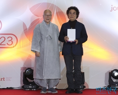 ‘2023 부산국제아트페어’ 대상 수상자인 이희돈 작가(오른쪽)에게 한인도수교교류위원장인 수불스님이 시상하고 있다.  사진=박정훈 기자