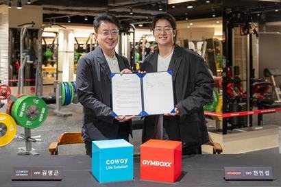 김명곤 코웨이라이프솔루션 대표이사(왼쪽)와 피트니스 브랜드 ‘짐박스’ 운영사 서플라이스의 천인섭 대표(오른쪽)가 짐박스 여의도점에서 열린 업무협약식에서 기념 촬영을 하고 있다. 사진=코웨이 제공
