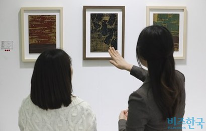 지난해 부산국제아트페어에서 설민기 작가(오른쪽)가 관람객에게 작품 설명을 해주는 모습. 사진=박정훈 기자