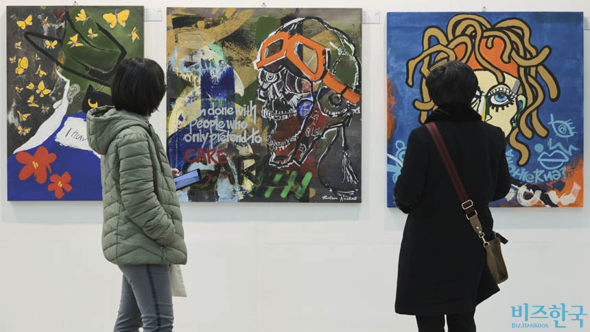 2025 유라시아부산국제아트페어에 참여한 배우 최민수의 작품을 관람객들이 감상하고 있다. 사진=박정훈 기자