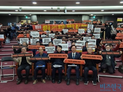 12월 10일 국회 의원회관에서 열린 ‘산업폐기물 피해증언과 제도개선을 위한 국회 토론회’에서 지역 주민이 피켓을 들고 기념 촬영을 하고 있다. 사진=김민호 기자