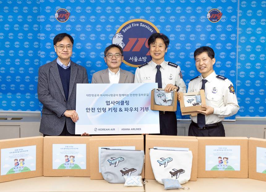 대한항공과 아시아나항공은 29일 서울 강서구 소재 강서소방서와 지온보육원에서 대한항공 기내 테이블보와 양사 객실승무원 폐유니폼을 재활용해 제작한 ‘업사이클링 안전 인형 키링 및 파우치’ 350개를 기부하는 행사를 가졌다. 행사에 참여한 대한항공 총무부담당 지상휘 상무(왼쪽에서 두 번째), 아시아나항공 HR담당 정성원 상무(왼쪽에서 첫 번째), 강서소방서 이원석 서장(왼쪽에서  세번째), 강서소방서 조철수 행정과장(왼쪽에서 네 번째)이 기념사진을 촬영하는 모습. 사진=대한항공 제공