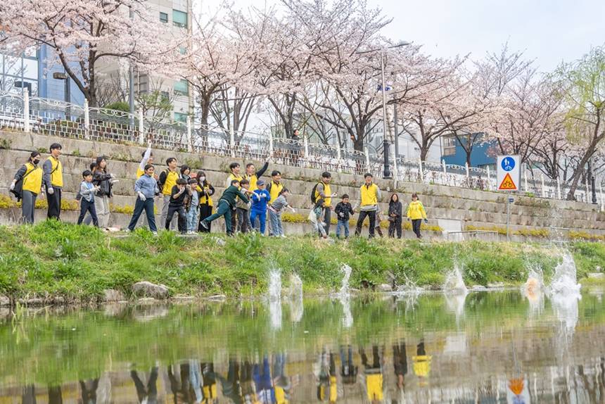 HDC현대산업개발은 지역사회에 대한 이해도를 높이고 지속 가능한 나눔을 실천하기 위해 릴레이 봉사활동을 진행했다. 지난 4월 성북천 일대에서 HDC현대산업개발 임직원들은 지역 주민, 어린이들과 함께 환경정화 활동을 하는 모습. 사진=HDC현대산업개발 제공