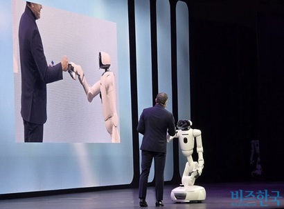 LG전자는 CES를 하루 앞둔 5일(현지시각) ‘LG 월드 프리미어’를 열고 ‘행동하는 AI’와 ‘​무노정 가정’에 대한 비전을 공개했다.&nbsp;홈로봇 ‘LG 클로이드’가 스티브 스카브로 LG전자 미국법인 ES CAC 실장과 주먹인사를 나누고 있다. 사진=강은경 기자
