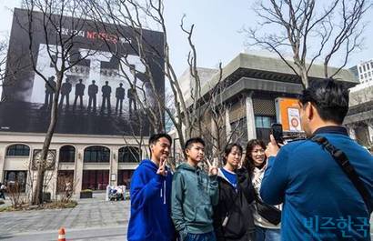 지난 3월 27일 BTS 컴백 공연을 맞아 광화문 광장을 방문한 외국인 관광객들이 BTS 광고판 앞에서 기념사진을 찍고 있다. 사진=최준필 기자