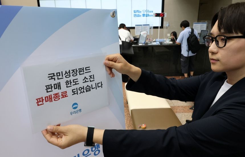 국민참여성장펀드 가입 첫날인 5월 22일 서울 중구 우리은행 본점 영업점에서 직원이 한도소진으로 인한 판매종료 안내문을 붙이고 있다. 사진=연합뉴스